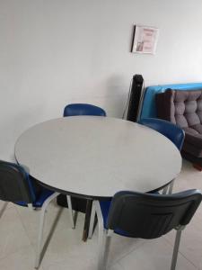 佩雷拉HABITACION CERCA AL AEROPUERTO的一张带蓝色椅子的白色桌子和一张沙发