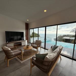 a living room with a couch and chairs and a television at St Michaels Ocean View House in El Zonte