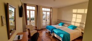 a hotel room with two beds and a window at Hotel Miramar Playa America Nigran in Nigrán
