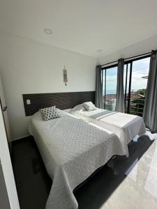 a bedroom with two beds and a large window at St Michaels Ocean View House in El Zonte