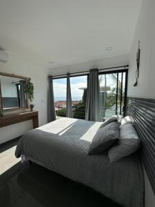 a bedroom with a bed and a large window at St Michaels Ocean View House in El Zonte +46 photos