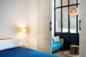 a bedroom with a blue bed and a window at Hotel Casa Bonay & Spa in Barcelona