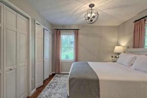 a bedroom with a bed and a window and a chandelier at Stunning Modern Rustic Lake Retreat PRVT BOAT SLIP in Cullowhee