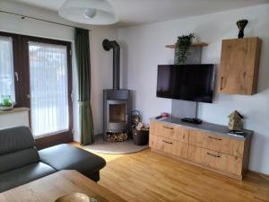 a living room with a flat screen tv on a wooden dresser at Ferienwohnung Dallinger in Anger
