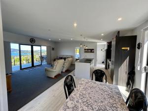 a kitchen and living room with a table and chairs at Waterview House in Cable Bay