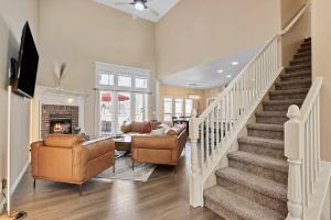 a living room with a staircase with a couch and chairs at Eagles Landing Spacious Family Getaway w Office in Eagle