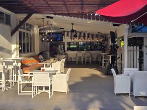 a restaurant with white chairs and tables and a bar at Hibiscus Retreat in Banks