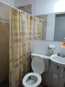 a bathroom with a white toilet and a sink at TRINIDAD in San Juan