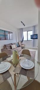 a living room with a table and chairs and a couch at Apartamento a Beira mar de Maceió in Maceió