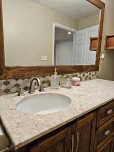 a bathroom counter with a sink and a mirror at Modern Stay with Hot tub in Douglasville +17 photos