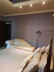 une chambre avec un lit blanc et une lampe dans l'établissement Luz do Sol Pousada 700m Praia do Peró, à Cabo Frio