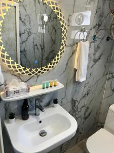 a bathroom with a sink and a mirror at شقة 8 واسعة وأنيقة ثلاث غرف نوم in Al Khobar
