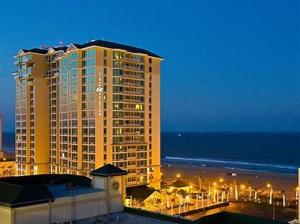 un grand bâtiment la nuit avec l'océan dans l'établissement Hilton Vacation Club Ocean Beach Club, à Virginia Beach