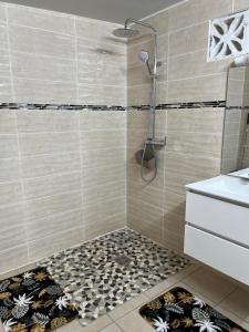 y baño con ducha y suelo de baldosa. en Suite nuptiale équipée, en Cochon Brûlé