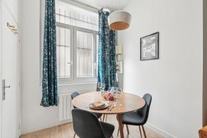 une salle à manger avec une table et des chaises et une fenêtre dans l'établissement L'Oasis Rouennais - Hypercentre - Gare rive Gauche, à Rouen