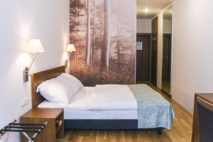 - une chambre avec un lit et une peinture murale dans l'établissement Benediktushaus im Schottenstift, à Vienne