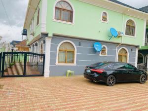 un coche negro estacionado frente a una casa en BOTS Two Bedroom Apartment, en Ilorin