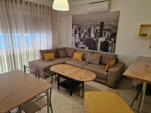 ein Wohnzimmer mit Sofa und Tisch in der Unterkunft Beachfront Apartment in Sarandë + 7 Fotos
