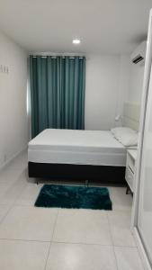 a bedroom with a bed and a green curtain at Alojamiento Arraial Do Cabo Golden Lake in Arraial do Cabo