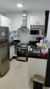 a kitchen with a stove and a sink at Alojamiento Arraial Do Cabo Golden Lake in Arraial do Cabo +8 photos