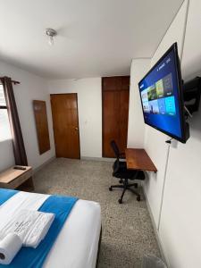 a room with a bed and a flat screen tv at Roomies House By Rincon in Medellín