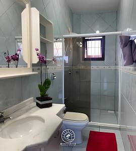 a bathroom with a shower and a toilet and a sink at Casa super aconchegante em Torres - Piscina - Pátio Privativo - Ar condicionado suíte - TV Smart - Wifi - Em frente a Lagoa do Violão - Aceita Pet in Torres