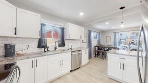 Awesome Two Bedroom Family Upper Unit in Denver في دنفر: مطبخ كبير مع دواليب بيضاء وطاولة