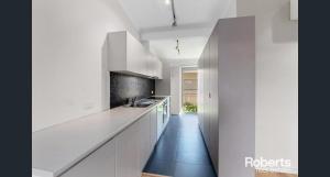 a white kitchen with white cabinets and a sink at Heavenly Hawley in Hawley Beach