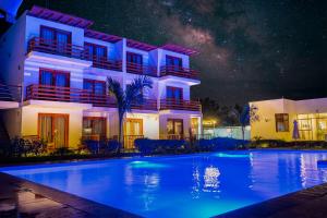 a house with a swimming pool at night at Hotel La Colina in Ica