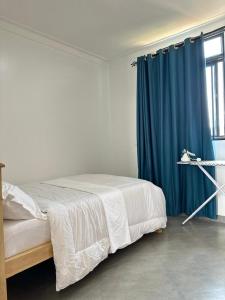 a bedroom with a bed with a blue curtain at Zaya Residency in Kampala