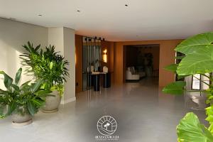 una hall con piante in vaso in un edificio di Apto em Torres - 250m do mar - Ar condicionado e TV smart sala e quartos - Wifi - Churrasqueira - Garagem coberta - Ao lado das Quatro Praças - Aceita Pet a Passo de Torres