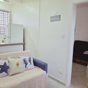 a living room with a couch with pillows on it at Apartamento Confortável a 350m da Praia dos Sonhos Itanhaém in Itanhaém