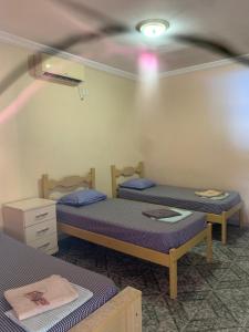 two twin beds in a room with a ceiling at Pousada Beiramar in Rio das Ostras