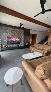 a living room with a couch and two tables at Ved Villa Netflix, Pool, Chill in Panchgani