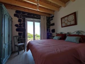 a bedroom with a large bed and a window at Armazéns do Beco - Cacau, Pimenta e Sal in Santa Cruz da Graciosa