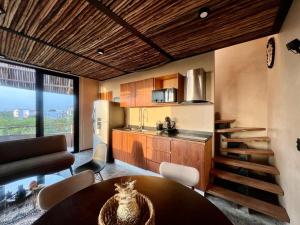 a kitchen and living room with a table and chairs at Atipika Tulum Apartments in Tulum