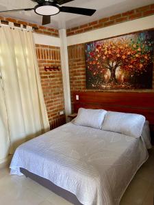 a bedroom with a bed with a painting on the wall at Cabaña El Anhelo Tradición in Ginebra +33 photos