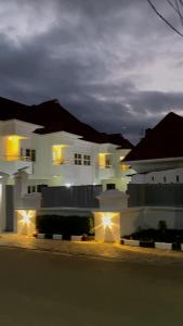 a white house with lights in front of it at BOTS 3 Bedroom Duplex Apartment in Oko Erin