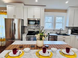 a kitchen with white cabinets and a vase of flowers on a table at Delightful dwelling in Buffalo +23 photos