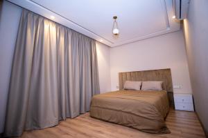 ein Schlafzimmer mit einem Bett und einem großen Fenster in der Unterkunft Luxury 2-Bedroom Apartment with Balcony - Heart of Gueliz in Marrakesch