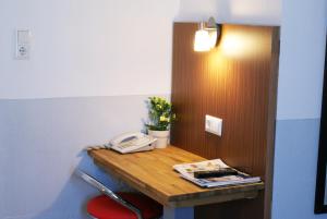 a desk with a phone and a phone in a room at Bahn-Hotel in Düsseldorf