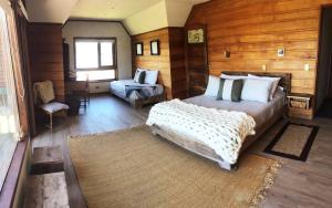 a bedroom with a large bed and a chair at Hotel Costanera in Villarrica
