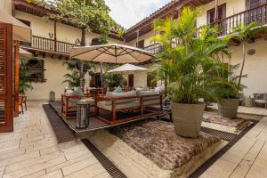 une terrasse avec une table, un parasol et des plantes dans l'établissement Ananda Hotel Boutique, à Carthagène des Indes