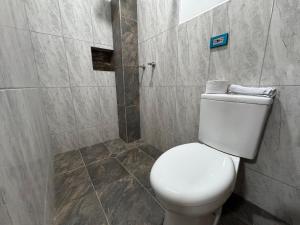 a bathroom with a white toilet and a shower at BYMAR Resort in Necoclí