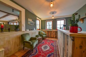 a large room with a bar with chairs and a rug at Gasthof Chiemseefischer in Grabenstätt