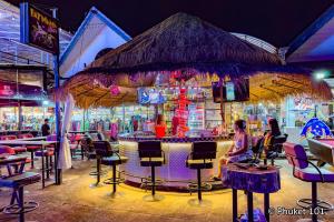 a bar in a restaurant with people sitting at it at TJ PATONG HOSTEL - Prime Location by OTOP Market & Sea in Patong Beach