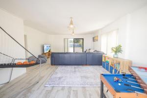 een woonkamer met een bank en een tafel bij Robinson Retreat, 3 Robinson St - 4 bedrooms, 2 bathrooms, air con and Wi-Fi in Anna Bay