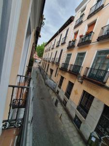 an empty street in an alley between two buildings at CH Lemon Rooms by HEBEROOMS in Madrid