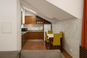 Una cocina y un comedor con una mesa y sillas amarillas. en Apartamento Centro das Furnas, en Furnas