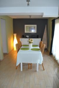 una sala da pranzo con tavolo e sedie bianchi di Gîte de l'Espinette a Godarville